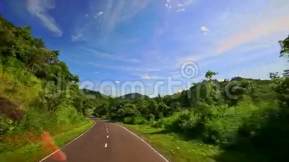 沿着弯曲乡村道路在丘陵景观之间的摄像机移动视频的预览图
