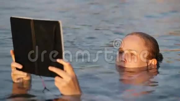 女人一边阅读一边漂浮在海里视频的预览图