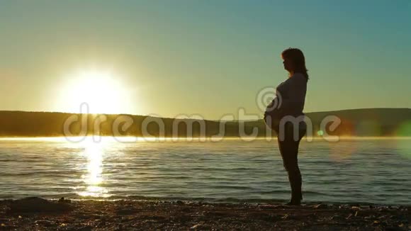 怀孕的剪影欣赏黎明的太阳视频的预览图