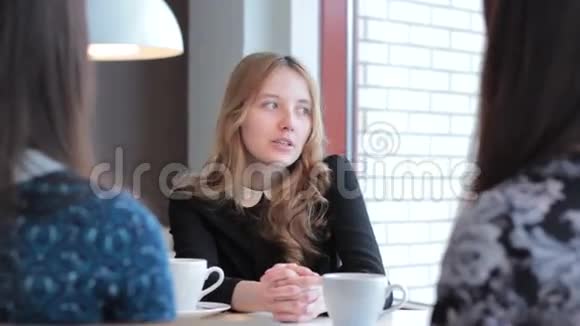 女孩在咖啡馆里讲述了她女朋友的故事视频的预览图