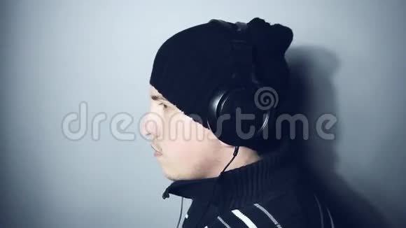 戴着冬帽听音乐的年轻人视频的预览图