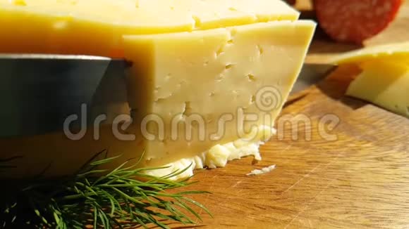 用刀子在木制慢镜头上切割奶酪视频的预览图