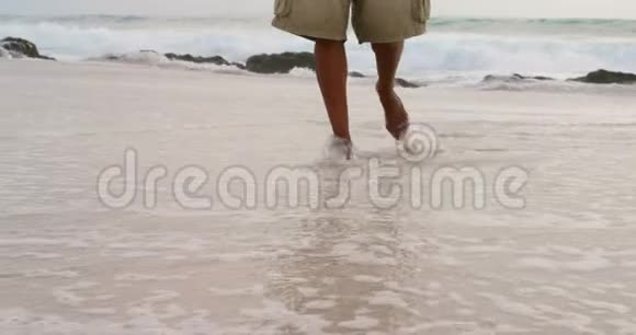 在阳光明媚的4k天气里一个人赤脚在海滩上行走视频的预览图