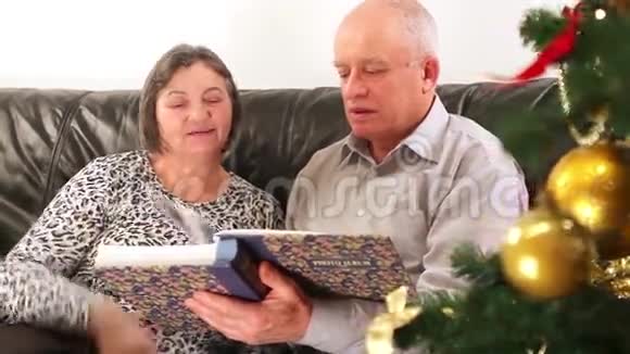 一对老夫妇正在看圣诞相册视频的预览图