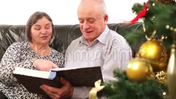 一对老夫妇正在看圣诞相册视频的预览图