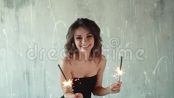 可爱的年轻女孩手里拿着火花假日的气氛慢动作视频的预览图
