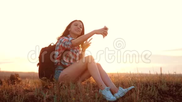 希普斯特徒步旅行者剪影女孩旅行者休息慢动作视频与背包学生做自拍自我视频的预览图