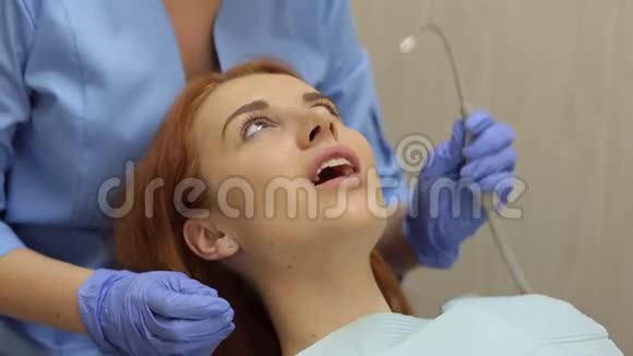 年轻女子坐在牙医椅上特写视频的预览图