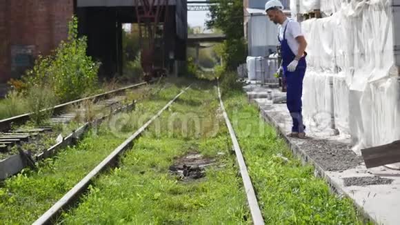 铁路工人戴着白盔沿着铁路行走视频的预览图