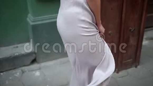 苗条的女孩穿着一件灰色的壮观裙子漂亮的腿在街上摆姿势视频的预览图