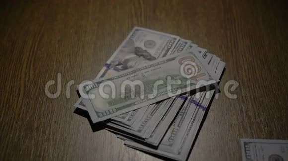 一叠100张钞票落在桌子上视频的预览图