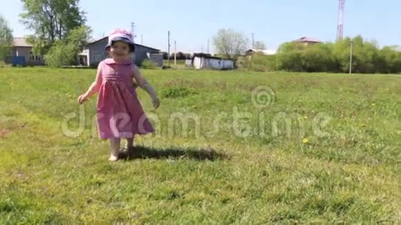 快乐的小女孩在阳光明媚的夏日草地上视频的预览图