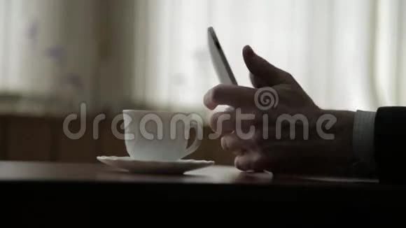 使用平板电脑和喝咖啡的人在窗户背景上特写双手视频的预览图