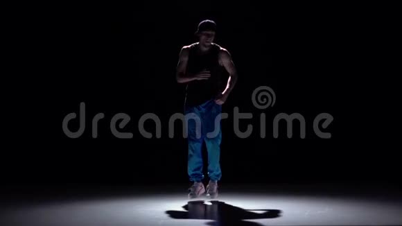 穿着蓝色裤子跳舞的有才华的舞者穿着黑色阴影慢动作视频的预览图