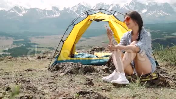 早上在岸上露营帐篷的年轻女子视频的预览图