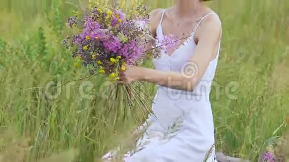 一位年轻女子坐在绿茵场上手里拿着一束鲜花视频的预览图