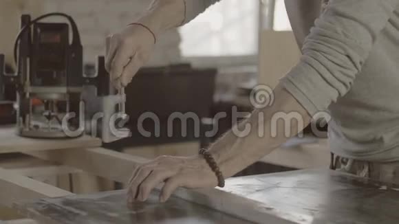 木工将金属块固定在木板上家具的制作过程视频的预览图
