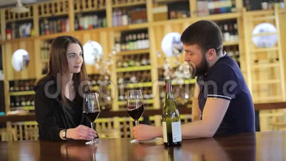 一个女孩和一个餐馆里的男人交流并喝红酒一对年轻夫妇在一张桌子上喝红酒视频的预览图