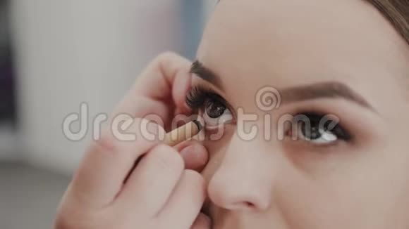 专业化妆师女士为美容院的客户画睫毛视频的预览图