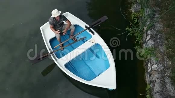 一个年轻人在森林附近的船上钓鱼视频的预览图