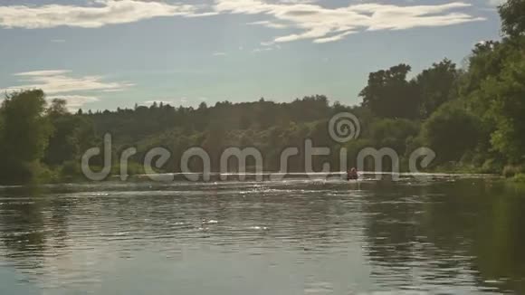 远处的人们在河上的小船上划着慢动作视频的预览图
