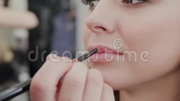 专业化妆师女士为美容院的客户画嘴唇视频的预览图