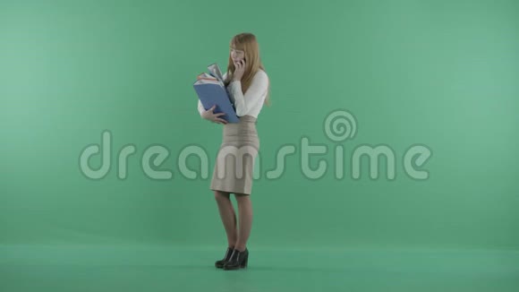 一个女孩正在用一堆文件打电话视频的预览图