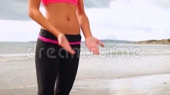 在海滩上练习瑜伽的黑发美女视频的预览图