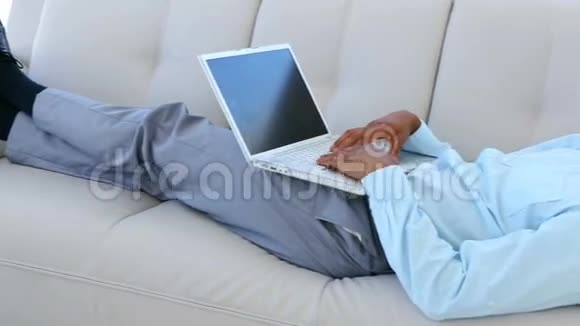 商人拿着笔记本电脑在沙发上睡着了视频的预览图