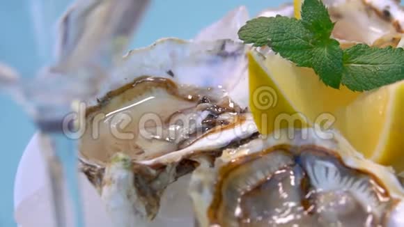 用冰块和柠檬在白色盘子上打开牡蛎视频的预览图