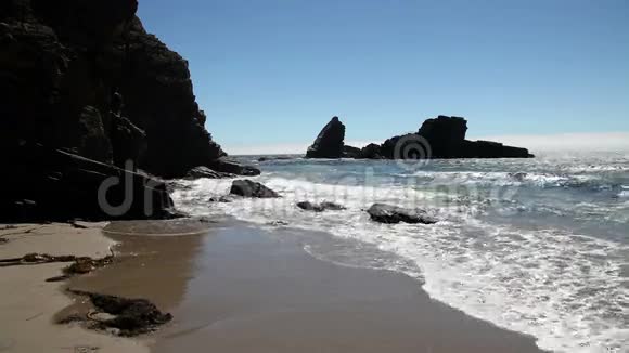 沙滩上有岩石和海藻视频的预览图