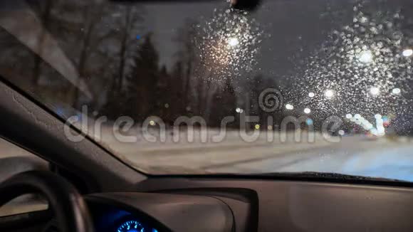 透过雪和潮湿的挡风玻璃看到模糊的街道轮廓视频的预览图