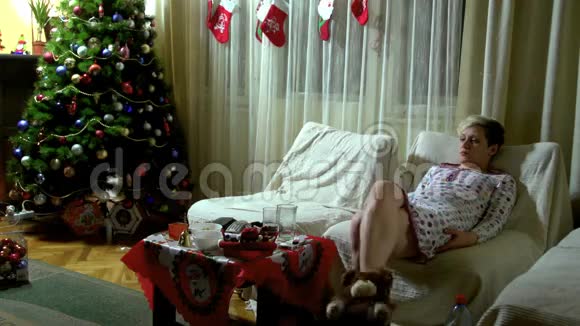 在圣诞节晚上坐沙发的女人视频的预览图
