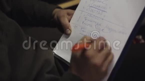 人用钢笔在一张纸上的列表中划线单词写小纸条视频的预览图