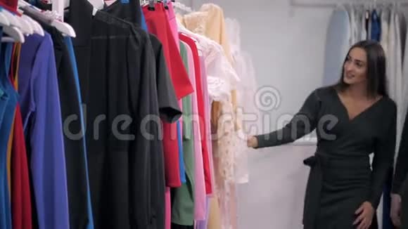 两个女朋友在购物中心散步带着袋子和选择衣服视频的预览图