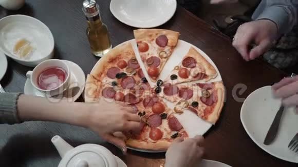 手拿比萨饼切顶视图特写镜头在咖啡馆里交流和朋友视频的预览图