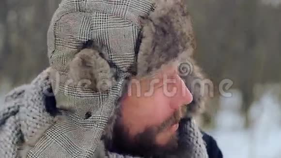 冬天有胡子的人拿苹果的肖像一个留胡子的年轻人在冬天吃苹果视频的预览图