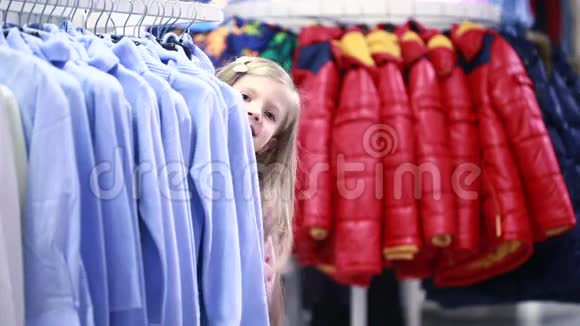 时尚的商店服装店里的小女孩选一套西装视频的预览图