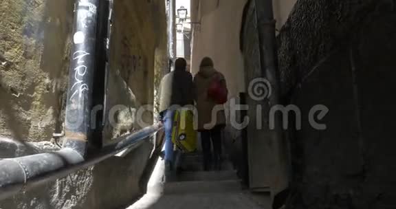 两个游客走在狭窄的老街上视频的预览图