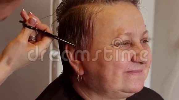 关闭理发师理发专业发型师的手快乐的成年女人视频的预览图