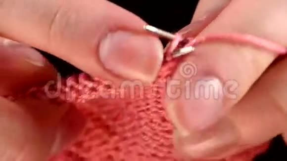 编织粉色围巾的女人的手特写视频的预览图
