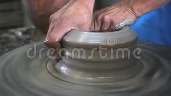 双手合拢陶工车轮上的粘土视频的预览图