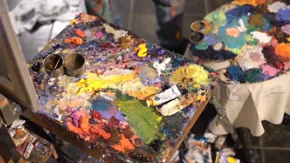 艺术家将各种颜色的油画颜料混合在托盘上视频的预览图