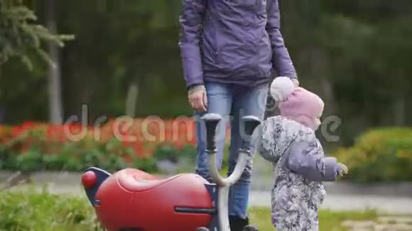 幸福的家庭爸爸妈妈和小女孩在秋天公园散步爸爸和宝宝在操场玩耍视频的预览图