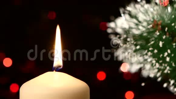 上面有一支白色的大蜡烛和圣诞节视频的预览图