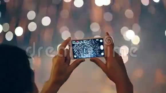一个男人用手机拍摄五颜六色的焰火视频的预览图