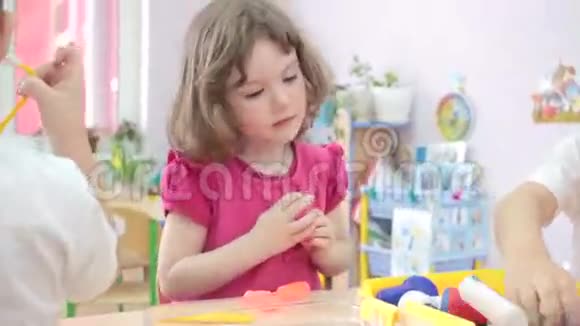 小女孩在幼儿园和其他孩子玩医生视频的预览图