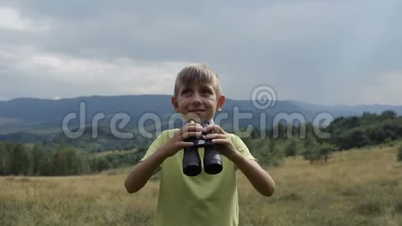 男孩站在山顶看着望远镜视频的预览图