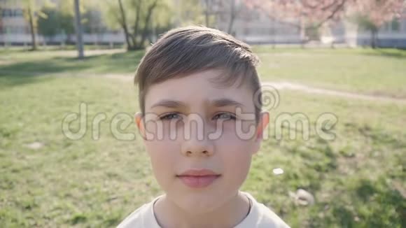 10岁男孩在春天或夏天绿色植物背景上的肖像视频的预览图