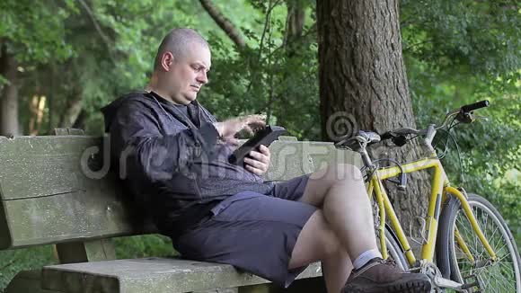 有平板电脑的人在公园里骑自行车视频的预览图